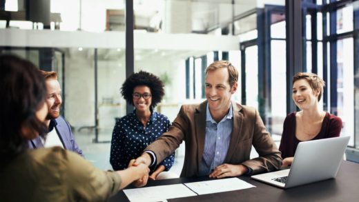 Businessman shaking hands with team members