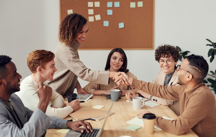 Businesswoman shaking hands with her team member