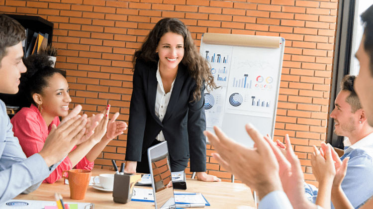 entrepreneurship development and business communication - a businesswoman finishing a speech, audience clapping 