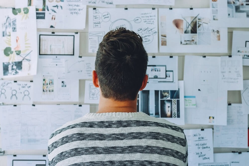 a guy looking at a planner-board